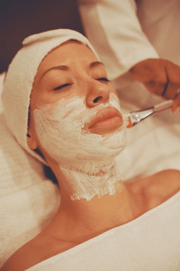 our-story-01 Close-up of a woman receiving a soothing facial mask at a spa, promoting relaxation and skincare.